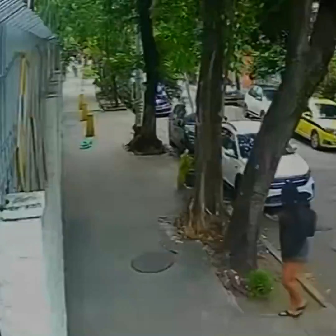 Terrifying moment woman falls down a manhole after cover gave way when she stepped on it (video)
