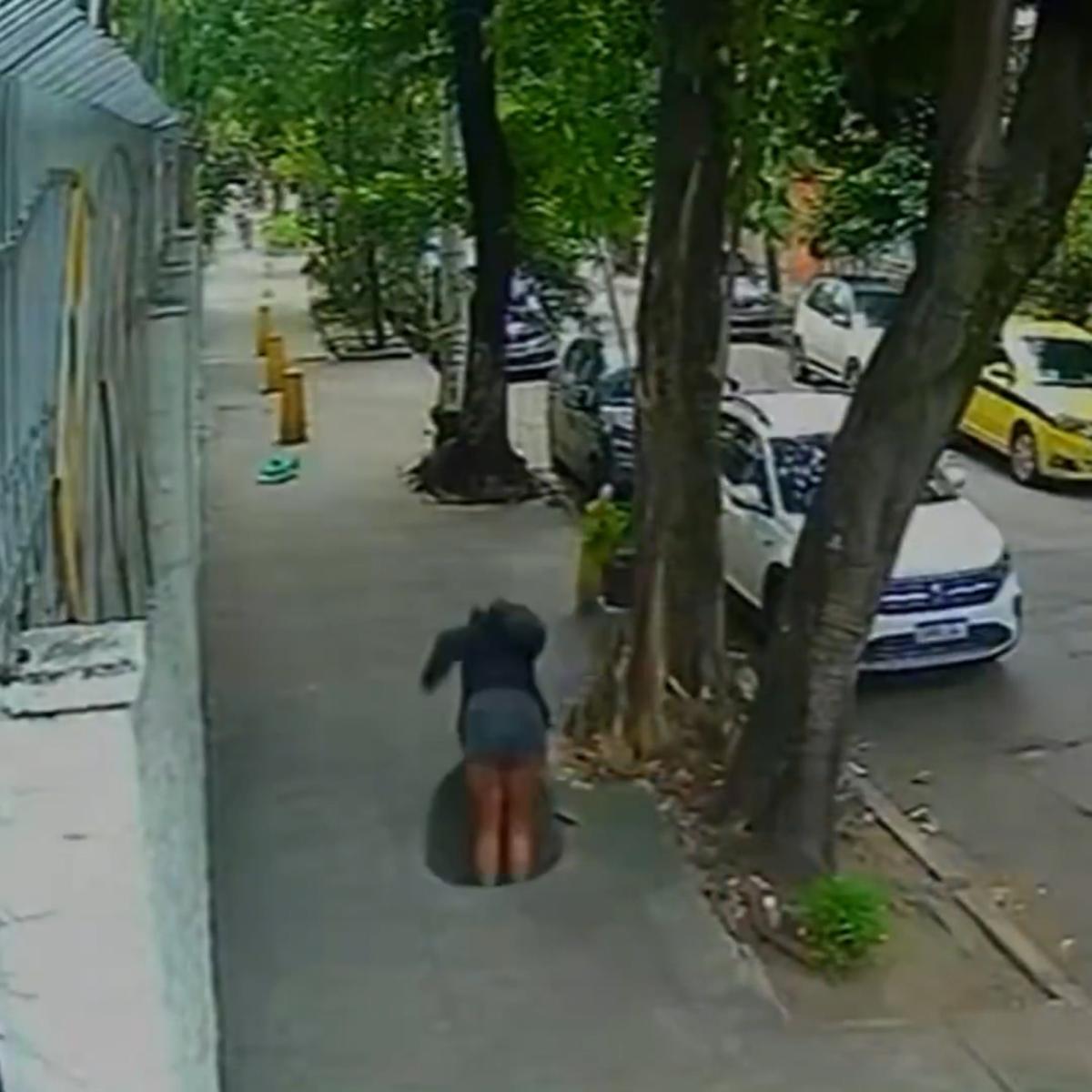 Terrifying moment woman falls down a manhole after cover gave way when she stepped on it (video)