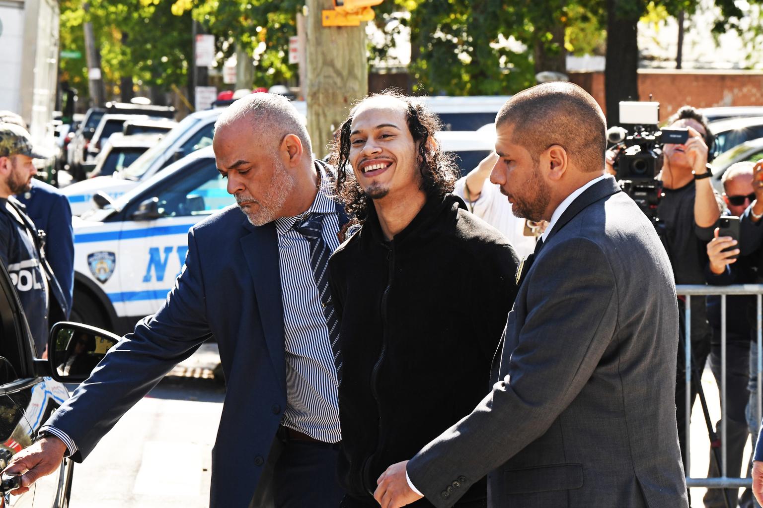 Man accused of pushing girlfriend and baby off NYC balcony smiles as he’s led away by cops