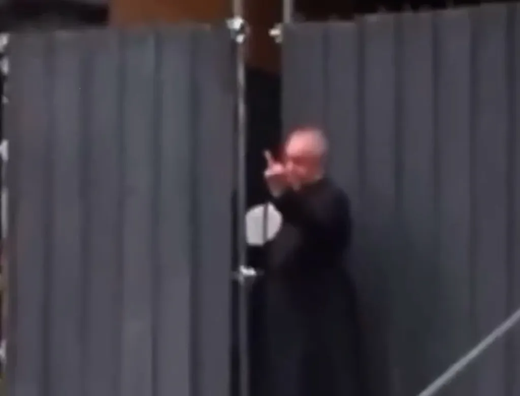 Italian priest gives protesters the middle finger while protecting his congregation from rioters