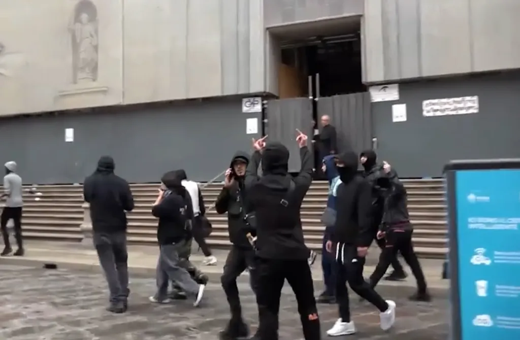 Italian priest gives protesters the middle finger while protecting his congregation from rioters
