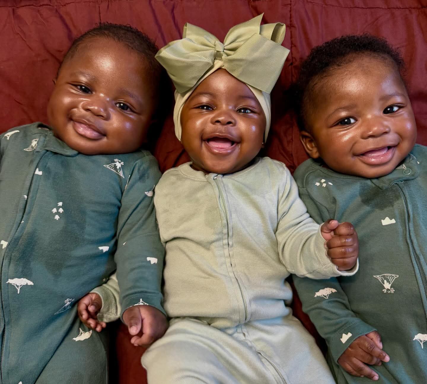 Nigerian woman dancing joyfully with her triplets