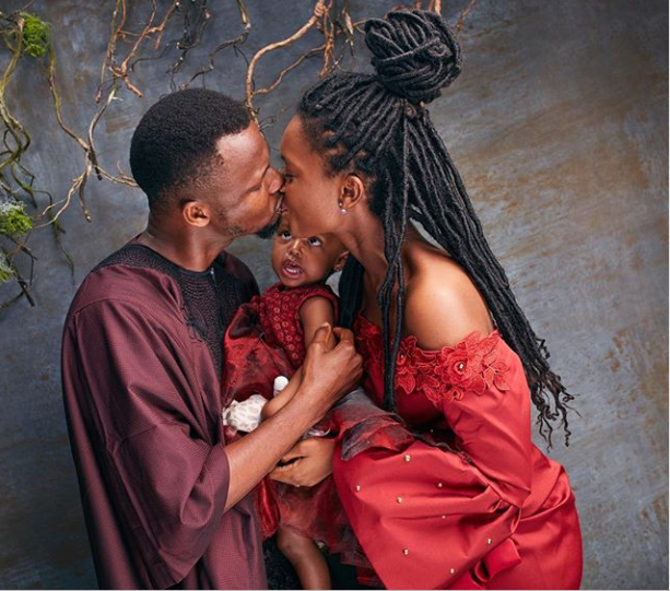 Cute photo of Comedian EmmaOhMaGod sharing a kiss with his wife as their daughter stares at them
