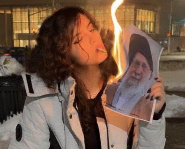 Iranian women light cigarettes with burning photo of their countryâs supreme leader